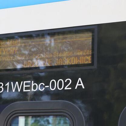 Zbliżenie na ekran informacji na ekranie wyświetlacza pociągu Kolei Śląskich, pokazujące trasę i harmonogram. (wygenerowano przez AI)
