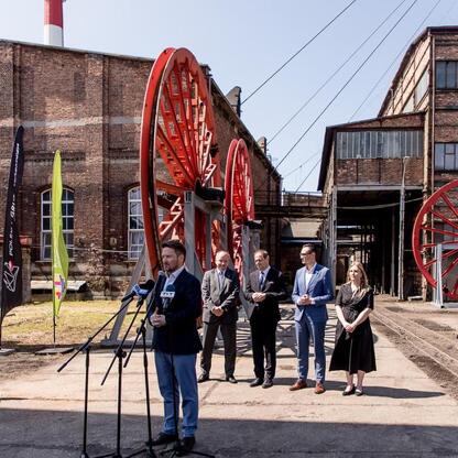 Przedstawiciele PGG, Województwa Śląskiego, Katowic i GZM na konferencji prasowej w byłym kopalni Wujek, podpisują list intencyjny o współpracy w rozwijaniu terenów po kopalni. (wygenerowano przez AI)