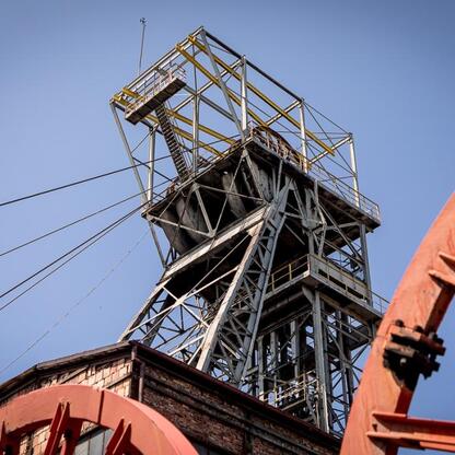 Zdjęcie przedstawia kompleksowy widok dawnego kopalni Wujek w Katowicach, obejmujący metalowe struktury i platformy, które świadczą o dawnej funkcji wydobywczej. (wygenerowano przez AI)