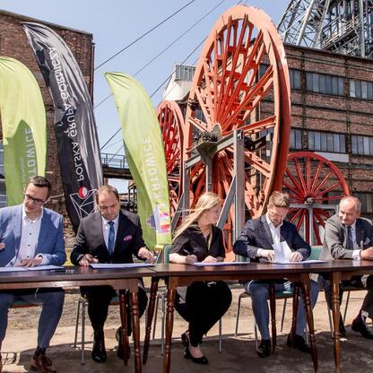 Przedstawiciele PGG, Województwa Śląskiego, Katowic i GZM podpisują dokument, koordynując przyszłość terenów po kopalni Wujek. (wygenerowano przez AI)