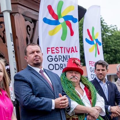 Zwiedzanie festiwalu w Raciborzu, uczestnicy w formalnej odzieży, promocja regionu. (wygenerowano przez AI)
