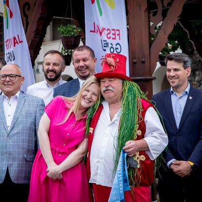 Grupa ludzi w formalnym stroju uczestniczy w festiwalu 
