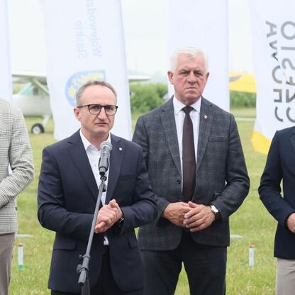 Grzegorz Boski, wicemarszałek Województwa Śląskiego, prowadzi konferencję prasową przed Air Show w Rudnikach. (wygenerowano przez AI)