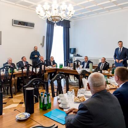 Formalna sesja w sali konferencyjnej, gdzie przedstawiciele programu 