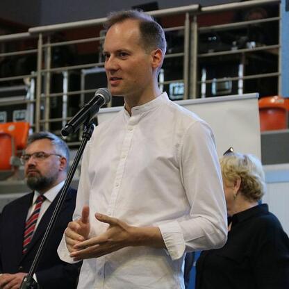 Mężczyzna przemawia do publiczności w hali w Bielsku-Białej, podczas II Dni Zdrowia. (wygenerowano przez AI)