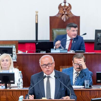 Formalna sesja Sejmiku Województwa Śląskiego, gdzie administracja otrzymuje wotum zaufania i absolutorium. (wygenerowano przez AI)