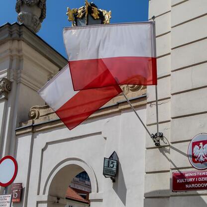 Wejście do Muzeum Górnictwa Węglowego w Zabrzu, z polskim flagą i emblematem MKiDN. (wygenerowano przez AI)