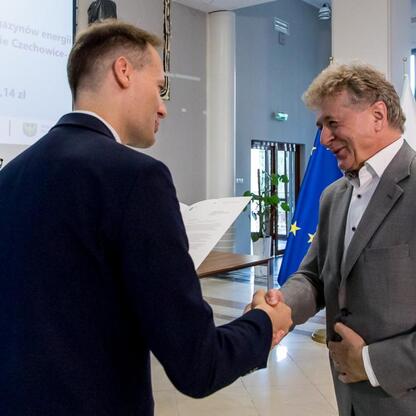 Grzegorz Boski, wicemarszałek Województwa Śląskiego, wręcza listy gratulacyjne beneficjentom projektów energetycznych finansowanych z Europejskich Funduszy. (wygenerowano przez AI)