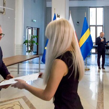 Wicemarszałek Grzegorz Boski wręcza listy gratulacyjne beneficjentom projektów energetycznych w Województwie Śląskim. (wygenerowano przez AI)