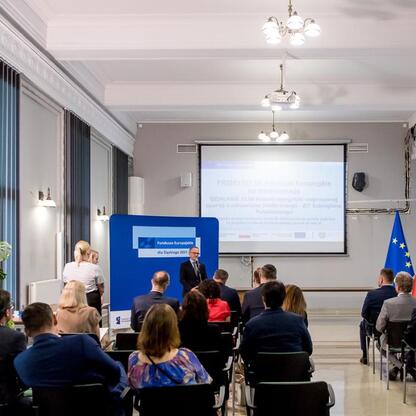 Wicemarszałek Grzegorz Boski wręcza listy gratulacyjne beneficjentom projektów z Europejskich Funduszy dla Śląska. (wygenerowano przez AI)