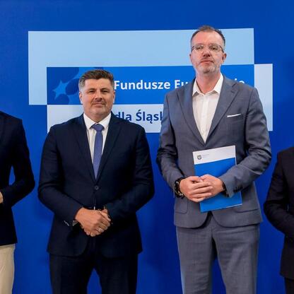 Wicemarszałek Grzegorz Boski i jego współpracownicy przedstawiają beneficjentom listy gratulacyjne w ramach programu Fundusze Europejskie dla Śląska. (wygenerowano przez AI)