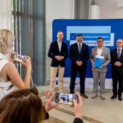 Grzegorz Boski, wicemarszałek Województwa Śląskiego, zastępuje listy gratulacyjne dla beneficjentów projektów energetycznych w ramach Funduszy Europejskich dla Śląska 2021-2027. (wygenerowano przez AI)