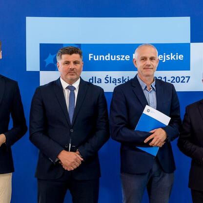 Wicemarszałek Grzegorz Boski i jego współpracownicy przedstawiają beneficjentom Funduszy Europejskich dla Śląska 2021-2027 listy gratulacyjne. (wygenerowano przez AI)