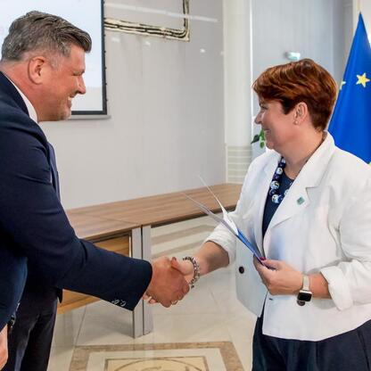 Sylwetka spotkania w Urzędzie Marszałkowskim Województwa Śląskiego, gdzie prezentowane są gratulacje dla beneficjentów projektów energetycznych. (wygenerowano przez AI)
