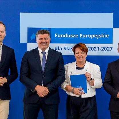 Wicemarszałek Grzegorz Boski wręcza listy gratulacyjne beneficjentom projektów energetycznych finansowanych z Europejskich Funduszy dla Śląska. (wygenerowano przez AI)