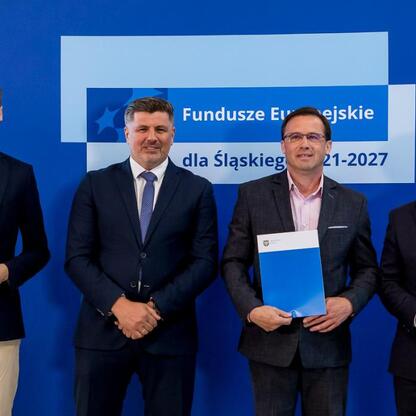 Wicemarszałek Grzegorz Boski i jego współpracownicy wręczają listy gratulacyjne w ramach projektu Fundusze Europejskie dla Śląska 2021-2027. (wygenerowano przez AI)