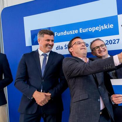 Wicemarszałek Grzegorz Boski i jego współpracownicy uczestniczą w selfie podczas uroczystości związanych z Europejskimi Funduszami dla Śląska 2021-2027. (wygenerowano przez AI)