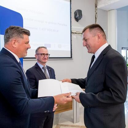 Grzegorz Boski, wicemarszałek Województwa Śląskiego, wręcza listy gratulacyjne beneficjentom projektów energetycznych. (wygenerowano przez AI)