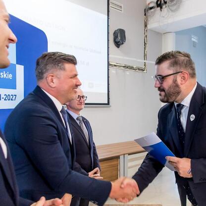 Wicemarszałek Grzegorz Boski wręcza listy gratulacyjne beneficjentom projektów promujących efektywność energetyczną i odnawialne źródła energii w Silesia. (wygenerowano przez AI)