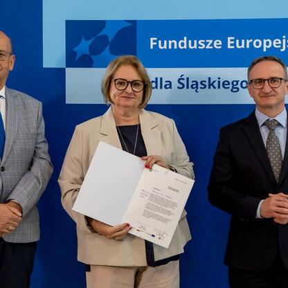 Wicemarszałek Grzegorz Boski prezentuje listy gratulacyjne dla beneficjentów projektów energetycznych województwa śląskiego. (wygenerowano przez AI)