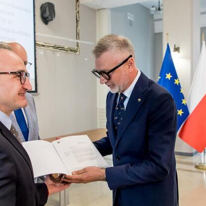 Grzegorz Boski, Wicemarszałek Województwa Śląskiego, wręcza listy gratulacyjne beneficjentom projektów energetycznych finansowanych z Europejskich Funduszy. (wygenerowano przez AI)