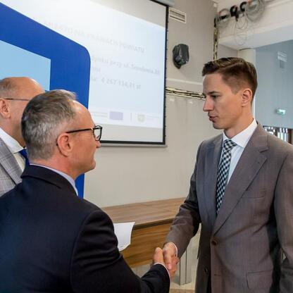 Wicemarszałek Grzegorz Boski wręcza listy gratulacyjne beneficjentom projektów energetycznych w Województwie Śląskim. (wygenerowano przez AI)