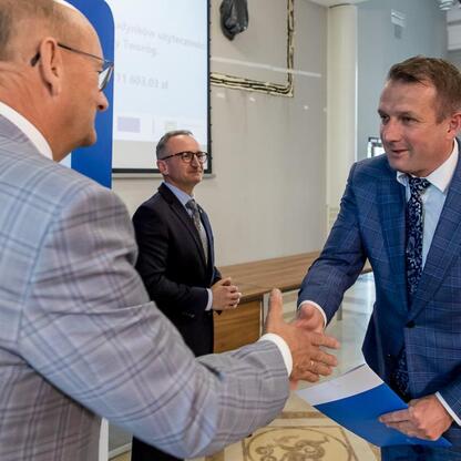 Wicemarszałek Grzegorz Boski wręcza listy gratulacyjne beneficjentom projektów energetycznych w Województwie Śląskim. (wygenerowano przez AI)
