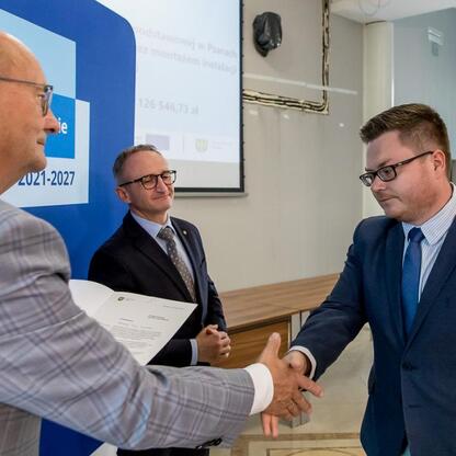 Grzegorz Boski, wicemarszałek Województwa Śląskiego, wręcza listy gratulacyjne beneficjentom projektów energetycznych. (wygenerowano przez AI)