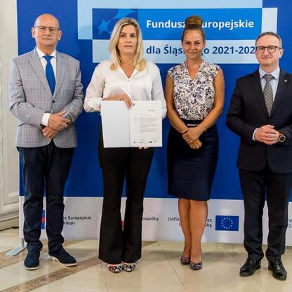 Wicemarszałek Grzegorz Boski i jego współpracownicy prezentują listy gratulacyjne beneficjentom konkursów związanych z rozwojem energetyki i efektywnością budynków użyteczności publicznej w ramach Fun (wygenerowano przez AI)