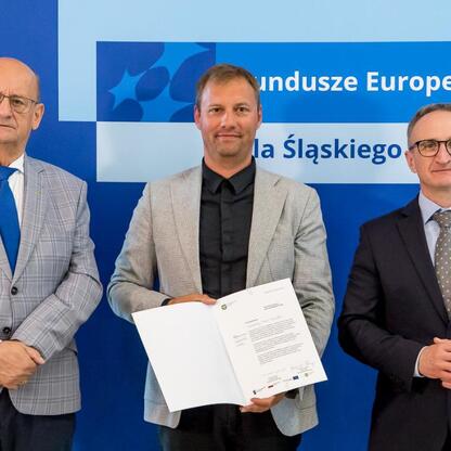 Wicemarszałek Grzegorz Boski wręcza beneficjentom listy gratulacyjne w ramach Europejskich Funduszy dla Śląska 2021-2027. (wygenerowano przez AI)