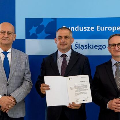 Grzegorz Boski, wicemarszałek Województwa Śląskiego, wręcza beneficjentom listy gratulacyjne w ramach Funduszy Europejskich dla Śląskiego 2021-2027. (wygenerowano przez AI)