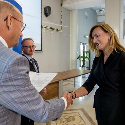 Grzegorz Boski, Wicemarszałek Województwa Śląskiego, wręcza gratulacje beneficjentom projektów z Europejskich Funduszy dla Śląska. (wygenerowano przez AI)