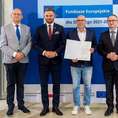 Wicemarszałek Grzegorz Boski wręcza listy gratulacyjne beneficjentom projektów energetycznych w ramach Funduszy Europejskich dla Śląska 2021-2027. (wygenerowano przez AI)