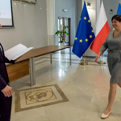 Wicemarszałek Grzegorz Boski wręcza gratulacje beneficjentom projektów energetycznych finansowanych z Unii Europejskiej. (wygenerowano przez AI)