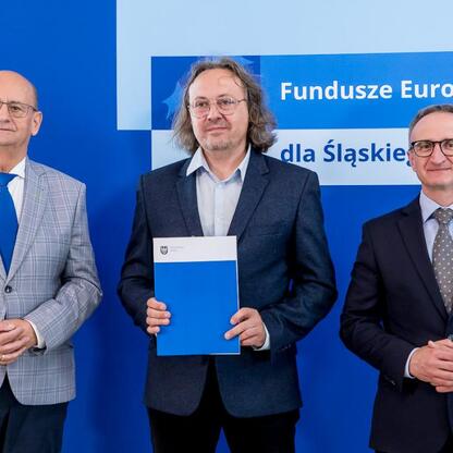 Grzegorz Boski, wicemarszałek Województwa Śląskiego, wręcza listy gratulacyjne beneficjentom konkursów związanych z rozwojem energetyki i efektywnością budynków użyteczności publicznej. (wygenerowano przez AI)