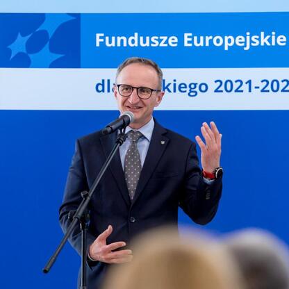 Wicemarszałek Województwa Śląskiego Grzegorz Boski przemawia na podium podczas konferencji o Funduszach Europejskich dla Śląska 2021-2027. (wygenerowano przez AI)