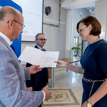 Grzegorz Boski wręcza gratulacje beneficjentom funduszy europejskich w Silesia. (wygenerowano przez AI)