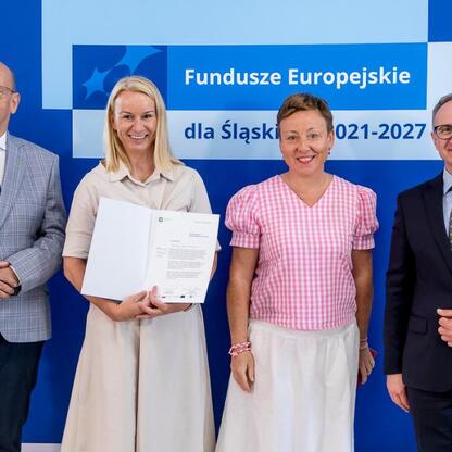 Grzegorz Boski, wicemarszałek Województwa Śląskiego, wręcza beneficjentom listy gratulacyjne w ramach Funduszy Europejskich dla Śląska 2021-2027. (wygenerowano przez AI)