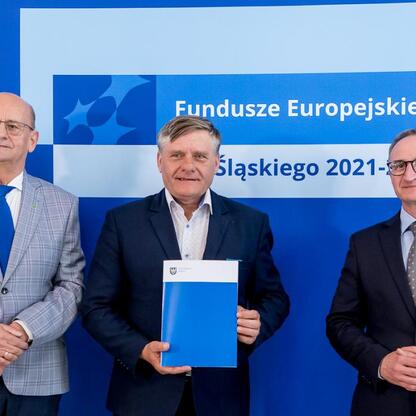 Wicemarszałek Grzegorz Boski i jego współpracownicy prezentują beneficjentom Funduszy Europejskich Śląskiego 2021-2027 listy gratulacyjne za projekty zrównoważonej energetyki. (wygenerowano przez AI)