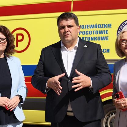 Trzech ludzi przed ambulancem Wojewódzkiego Pogotowia Ratunkowego w Zabrzu. (wygenerowano przez AI)