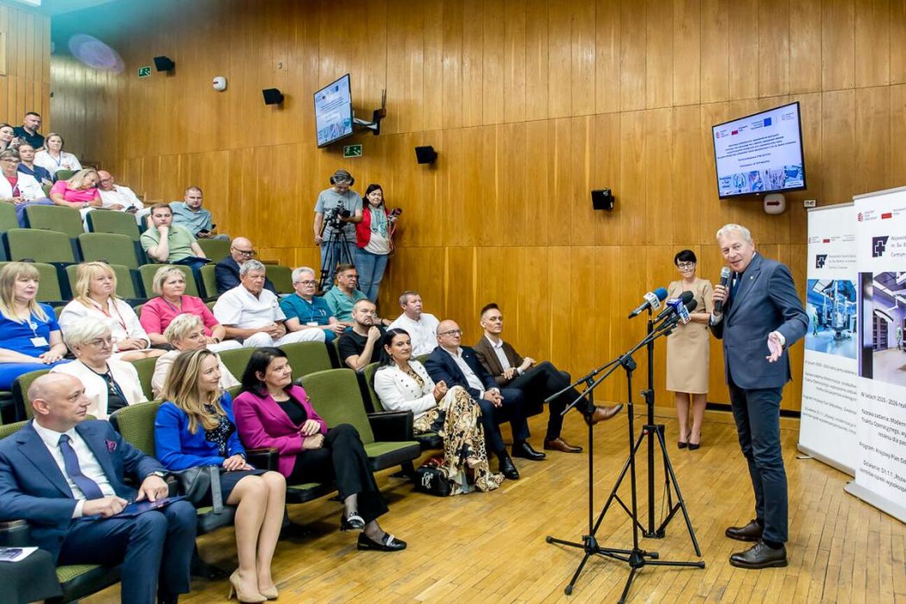 Wojciech Saługa, Marszałek Województwa Śląskiego, prowadzi konferencję prasową w Wojewódzkim Szpitalu Specjalistycznym im. św. Barbary w Sosnowcu, omawiając inwestycję w modernizację szpitala. (wygenerowano przez AI)