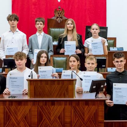 Grupa osób uczestniczących w ceremonii wręczenia nagród w konkursie 