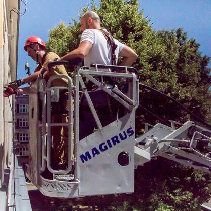 Pracownicy Urzędu Marszałkowskiego Województwa Śląskiego podczas ćwiczeń ewakuacyjnych na platformie Magirus. (wygenerowano przez AI)