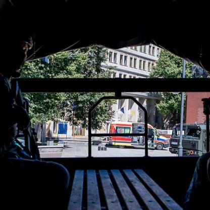 Zdjęcie przedstawia widok z wojskowego pojazdu na plac przed Urzędem Marszałkowskim Województwa Śląskiego w Katowicach, gdzie odbywały się ćwiczenia ewakuacyjne. (wygenerowano przez AI)