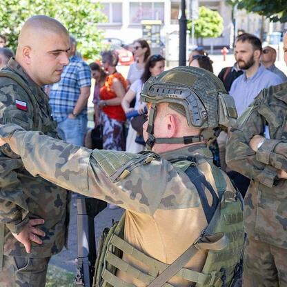 Zdjęcie przedstawia żołnierzy z 13 Śląskiej Brygady Obrony Terytorialnej podczas ćwiczeń ewakuacyjnych przed Urzędem Marszałkowskim w Katowicach. (wygenerowano przez AI)