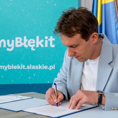 Urzędnik podpisuje umowę w kampanii 