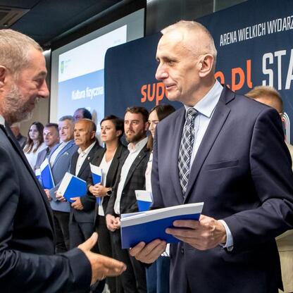 Leszek Pietraszek, Wicemarszałek Województwa Śląskiego, omawia wyniki konkursu ofert na kulturę fizyczną i bezpieczeństwo publiczne w Superauto.pl Stadion Śląski. (wygenerowano przez AI)
