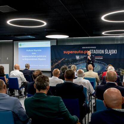 Wicemarszałek Leszek Pietraszek przemawia na ceremonii w Superauto.pl Stadion Śląski, gdzie ogłoszono zwycięzców konkursu ofert na zadania w dziedzinie kultury fizycznej i bezpieczeństwa publicznego. (wygenerowano przez AI)