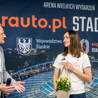 Na ceremonii w Superauto.pl Stadion Śląski, wicemarszałek Leszek Pietraszek przemawia, podczas gdy szpadzistka Martyna Swatowska-Wenglarczyk gratuluje. (wygenerowano przez AI)