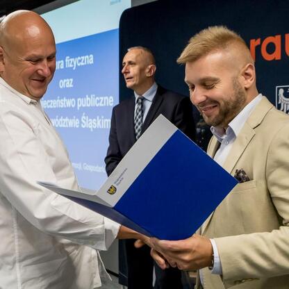 Wicemarszałek Leszek Pietraszek wspiera ceremonię podpisania dokumentów na Stadionie Śląskim, związanych z projektami kultury fizycznej i bezpieczeństwa publicznego. (wygenerowano przez AI)